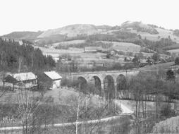 Bělá, černobílá fotografie, pohled na železniční most se čtyřmi oblouky