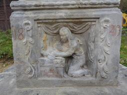 Sockel des gusseisernen Kreuzes in Slaná mit einem Relief von Maria Magdalena